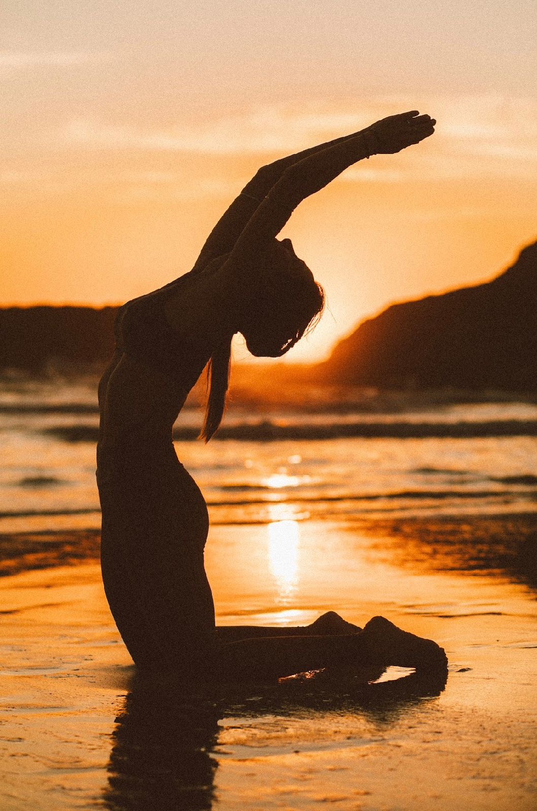 Pose de yoga ao amanhecer na praia